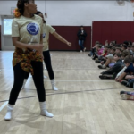 Artist in the Middle students showing dance moves to students